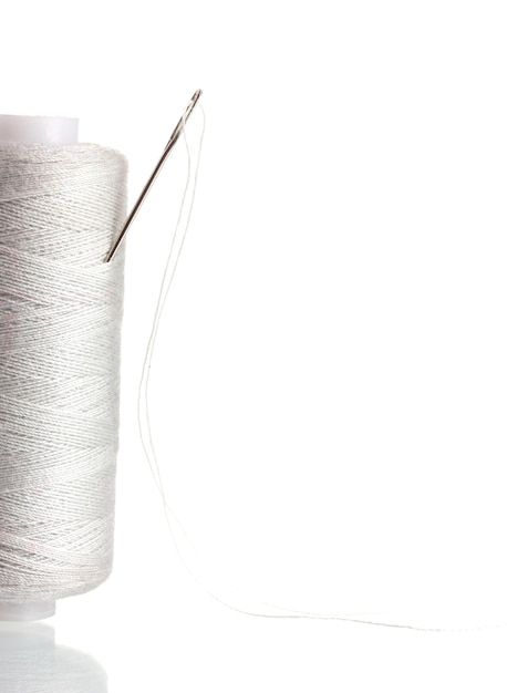 Zbliżenie nici i igły na tle tkaniny